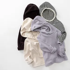 Flat lay view of cozy kids hooded sweatshirts in coffee, beige, purple and stripes