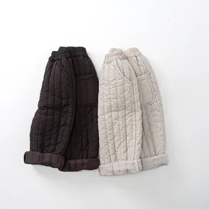 Détail des coutures verticales matelassées sur les pantalons chauds pour enfants marron et crème