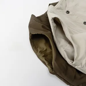 Détail de la texture d'un gilet enfant en coton et lin avec col rond et boutons noirs