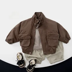 Flat lay of brown kids jacket, printed shirt, gray joggers, and sneakers outfit set