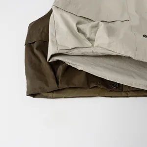 Détail macro du tissu du gilet en coton kaki et olive avec coutures et boutons