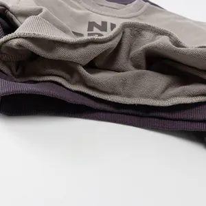 Close-up of premium cotton French Terry fabric texture on grey and purple sweatshirts