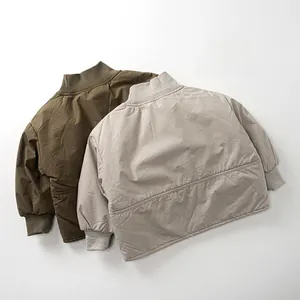 Flat lay detail of kids quilted pilot jackets in army green and beige with ribbed collars