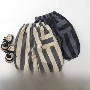 Detail of loose-fit striped kids' trousers with elastic cuffs and waist in warm fleece