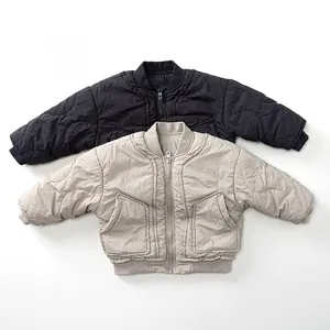 Flat lay of quilted lightweight kids' bomber jackets in black and beige grey tones