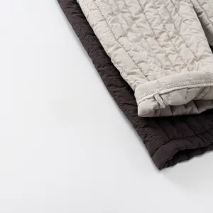 Détail du tissu matelassé et des coutures d'un pantalon d'hiver chaud pour enfants