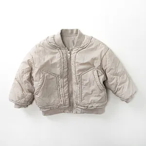 Detail of lightweight beige kids bomber jacket with ribbed collar and zipper pockets