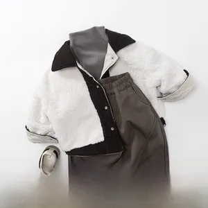 Flat lay of boys winter outfit with sherpa corduroy jacket, brown pants and grey sweater