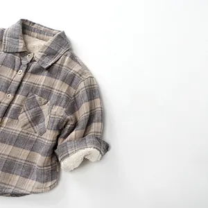 Détail de la doublure en sherpa chaud et tissu à carreaux gris sur chemise enfant