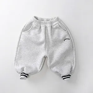 Détail du jogging pour enfants doublé polaire gris avec broderie Sunday et bords rayés