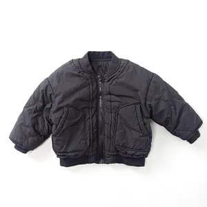 Detail view of black quilted kids jacket with ribbed cuffs and classic diamond patterns