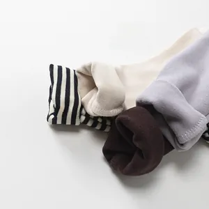 Close-up of thick fleece lining and ribbed cuffs on multi-color thermal kids' shirts