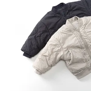 Detail of kids quilted bomber jackets featuring windproof ribbed collars and textured fabric