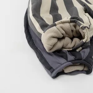 Detailed close-up of thick striped winter pants showing the warm fleece lining and fabric