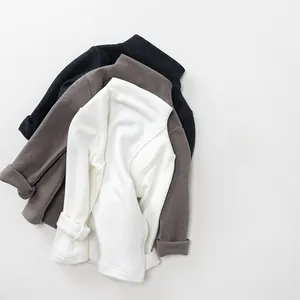 Detail of high-neck knit shirts for kids in white, brown and dark grey colors