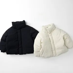 Detail of minimalist puffer jackets in black and cream with puffer quilting texture