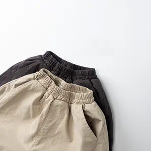 Détail d'un pantalon ample enfant doublé polaire avec taille élastique en beige et gris