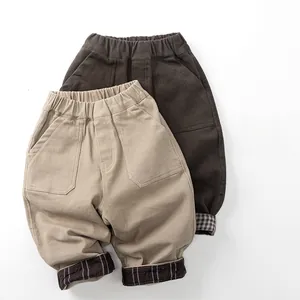 Detail of kids warm fleece trousers with elastic waist and plaid lining cuff design