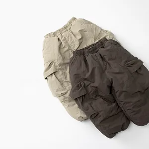 Detail view of khaki and brown cargo pants with elastic waist and side pockets