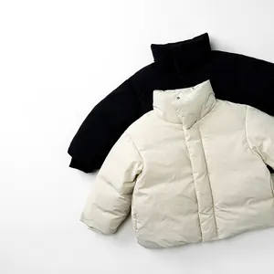Flat lay of kids minimalist hooded down jackets in black and cream white colors