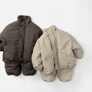 Flat lay of kids thermal winter set featuring padded high-neck jackets and joggers