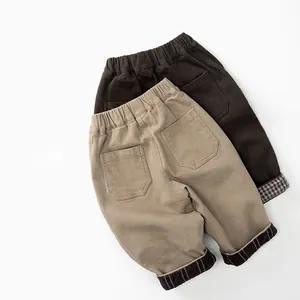 Detail view of children's fleece pants showing elastic waist and plaid cuffs lining