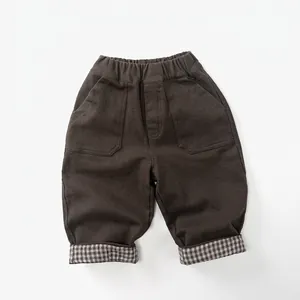 Detail of kids brown fleece pants with elastic waist and stylish plaid folded cuffs