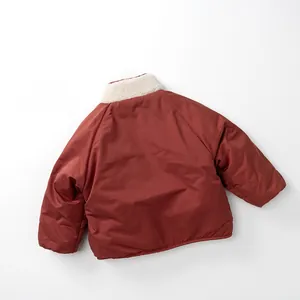 Detail of kids winter reversible jacket featuring warm fleece collar and deep brick red fabric