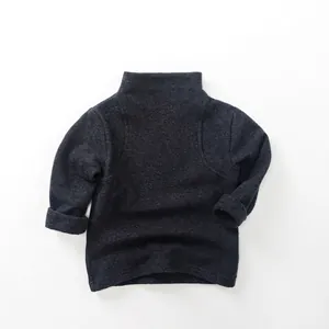Detail of dark grey kids turtleneck sweater showing premium knit texture and cuffed sleeves