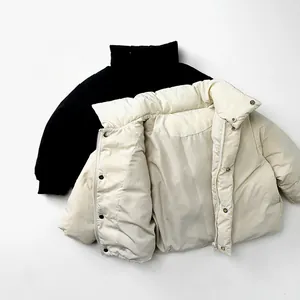 Detail view of the high stand collar with metal snap buttons and windproof sleeve cuffs