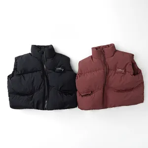 Dettaglio di gilet imbottiti per bambini in nero e bordeaux con cerniera lampo