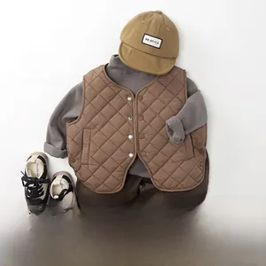 Flat lay of kids quilted brown vest, grey shirt, and trousers with plaid cuff detail