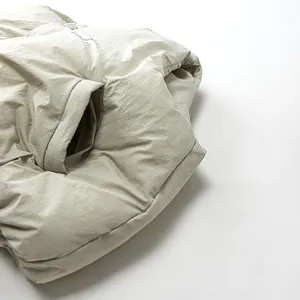 Detaillierte Nahaufnahme der Seitentaschen an der warmen beige Pufferweste für Kinder