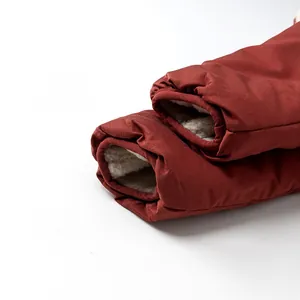 Close-up of deep red winter coat cuff showing thick white faux fur lining and warm texture