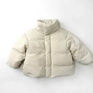 Detailed view of beige children down jacket with windproof stand collar and matte fabric