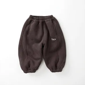Close-up of children's warm fleece sweatpants featuring elastic waist and letter print detail