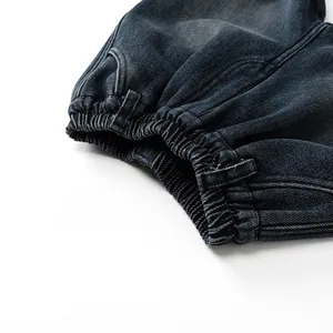 Détail du jean pour enfant avec taille élastique, délavage bleu marine et texture durable