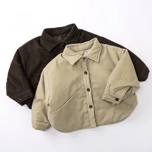 Flat lay of warm thick corduroy shirts for kids in dark brown and beige with button closure