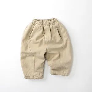 Detail view of elastic waistband and beige thick fabric texture on kids winter warm pants