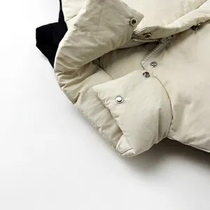 Kids quilted down jacket in cream beige with silver snap buttons and black lining detail
