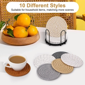 Set of 10 round woven cotton coasters in neutral tones with a black metal storage holder