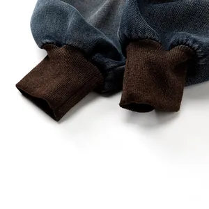 Détail d'un pantalon en jean bleu vintage avec poignets coupe-vent côtelés marron