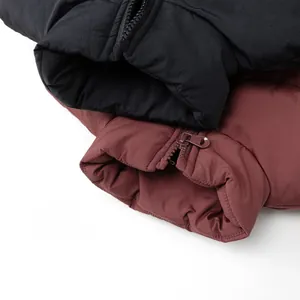 Dettaglio del tessuto opaco e della cerniera in metallo del gilet invernale per bambini