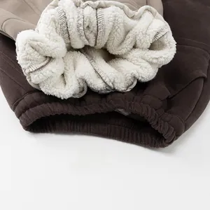 Nahaufnahme von weißem Lammwollfutter und Rippbündchen an warmen Kinder-Winterhosen