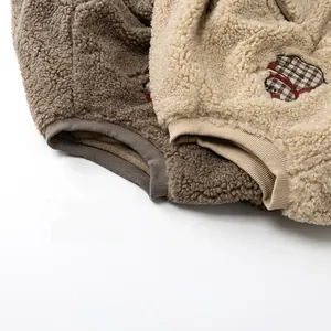 Gros plan détaillé de gilets en polaire pour enfants avec broderie ours et col côtelé