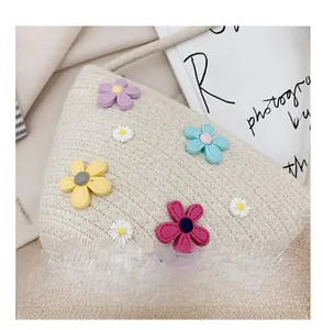 Détail du mini sac en paille tissé avec fleurs en 3D colorées et texture précise