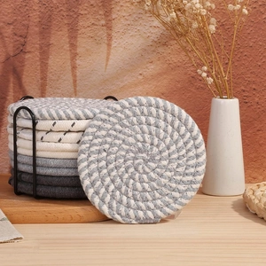 Thick cotton woven coasters set with black metal storage holder on wooden desk