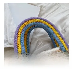 Dettaglio ravvicinato dei manici intrecciati arcobaleno e trama della borsa di paglia