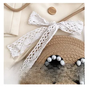 Detail view of woven straw texture with white lace bow and pearl decoration