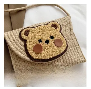 Detail showing handwoven texture and 3D teddy bear patch on beige bohemian bag